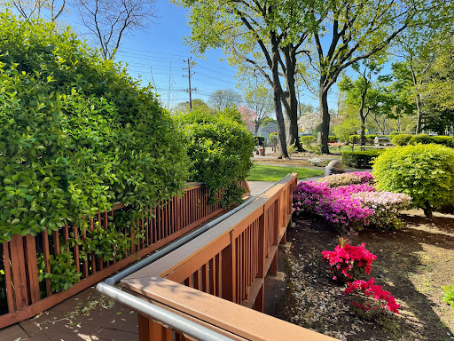 A serene garden path bordered by vibrant flowers and lush greenery, inviting visitors to explore the beauty of nature.