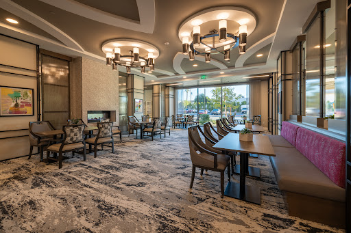A stylish and modern lounge area featuring elegant chandeliers, comfortable seating, and a spacious design.
