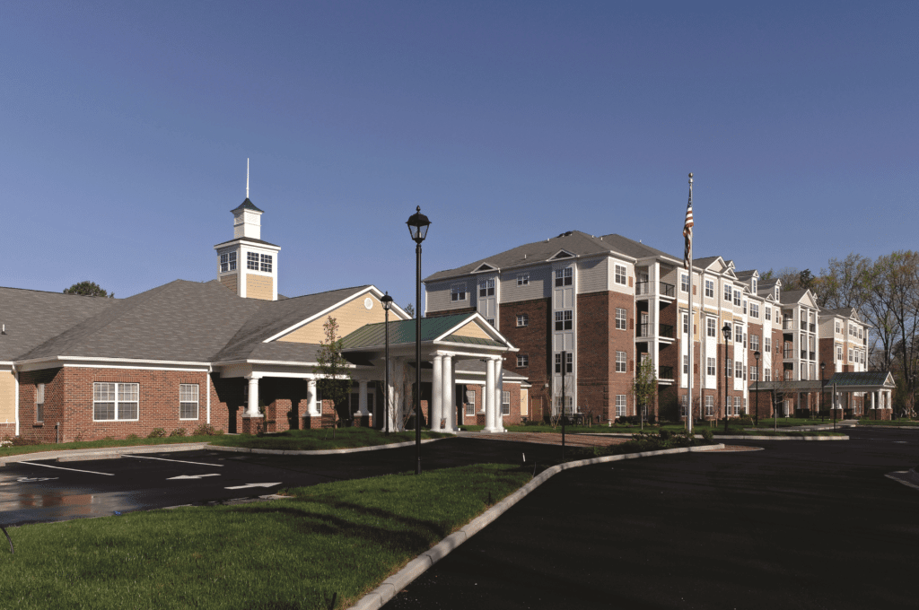 A modern apartment complex with brick and beige exteriors under a clear blue sky.