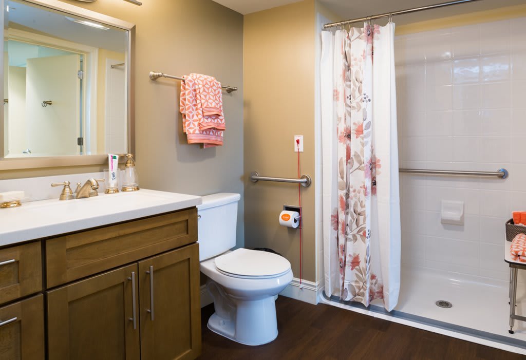 A modern bathroom with a shower, toilet, and sink.