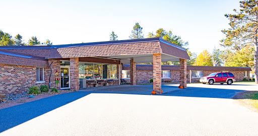 A modern commercial building with a brick facade, featuring large windows and a spacious parking area.