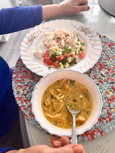 A delicious meal featuring chicken soup and a fresh salad with rice.