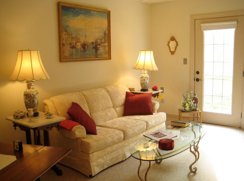 A cozy living room with a beige sofa, decorative pillows, and ambient lighting.