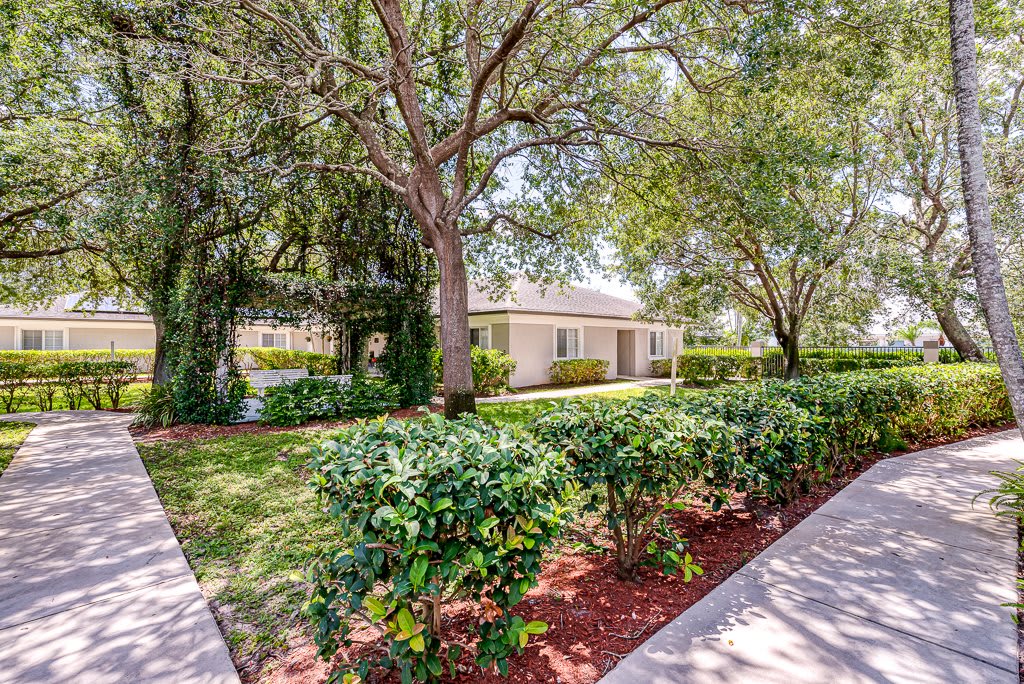A peaceful residential home surrounded by lush greenery and well-maintained landscaping.
