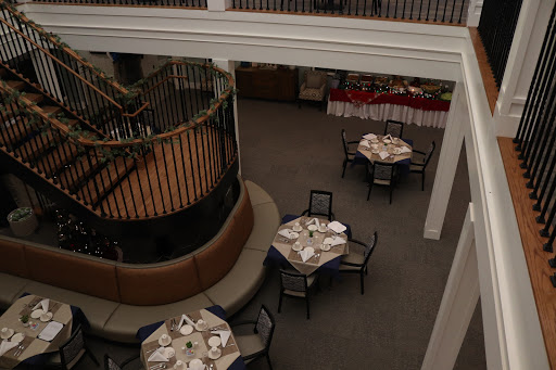 An elegant restaurant interior featuring well-set dining tables and a decorative staircase.