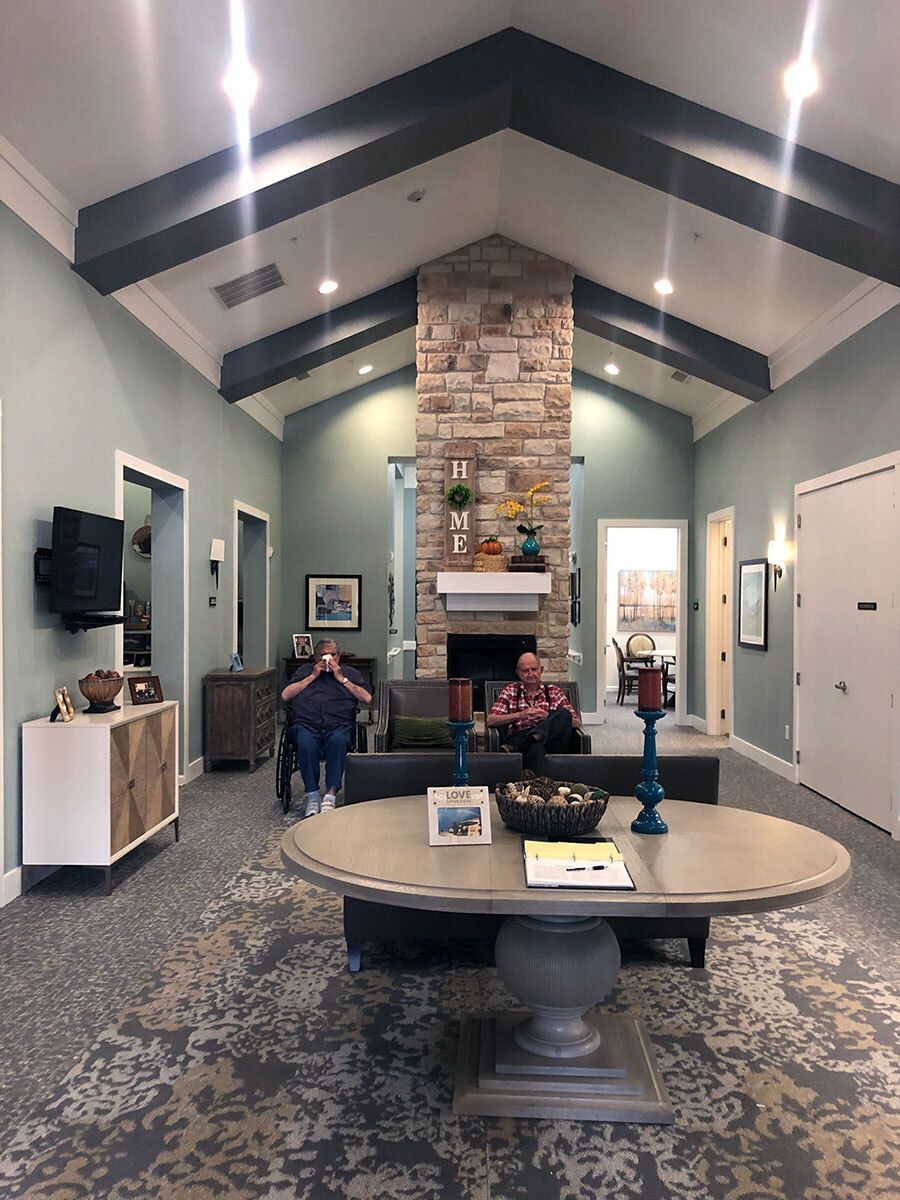 A cozy living room with a vaulted ceiling, stone fireplace, and comfortable seating.