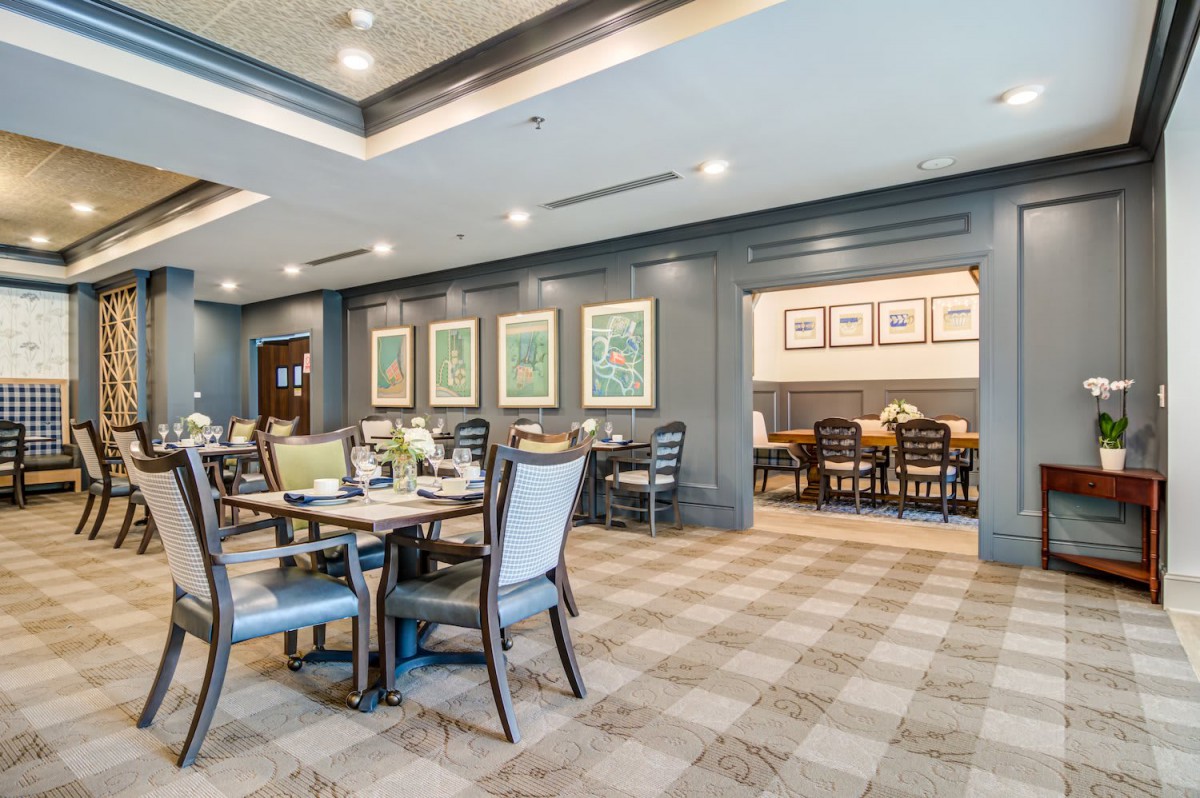 A modern dining area with elegant tables, chairs, and framed artwork adorning the walls.