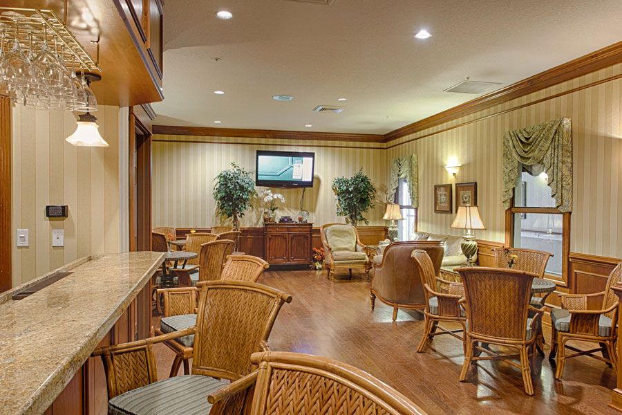 A cozy lobby with wicker furniture, warm lighting, and a television.