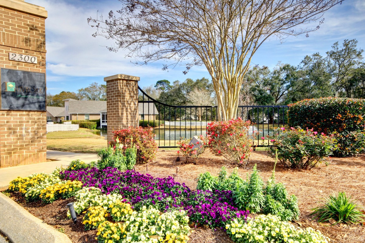 A beautifully landscaped garden with vibrant flowers and a decorative fence under a clear blue sky.