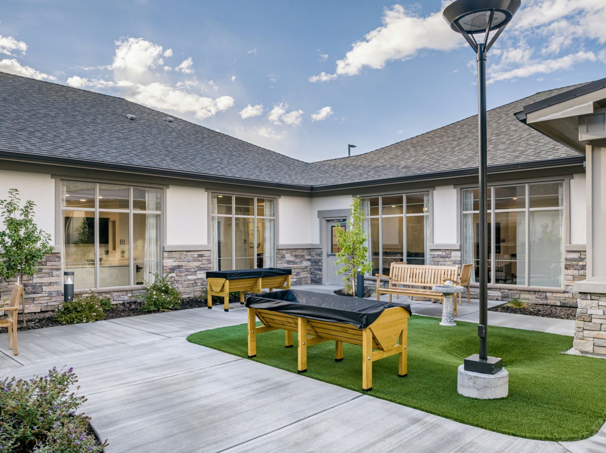 A modern courtyard with benches and outdoor furniture surrounded by a building.