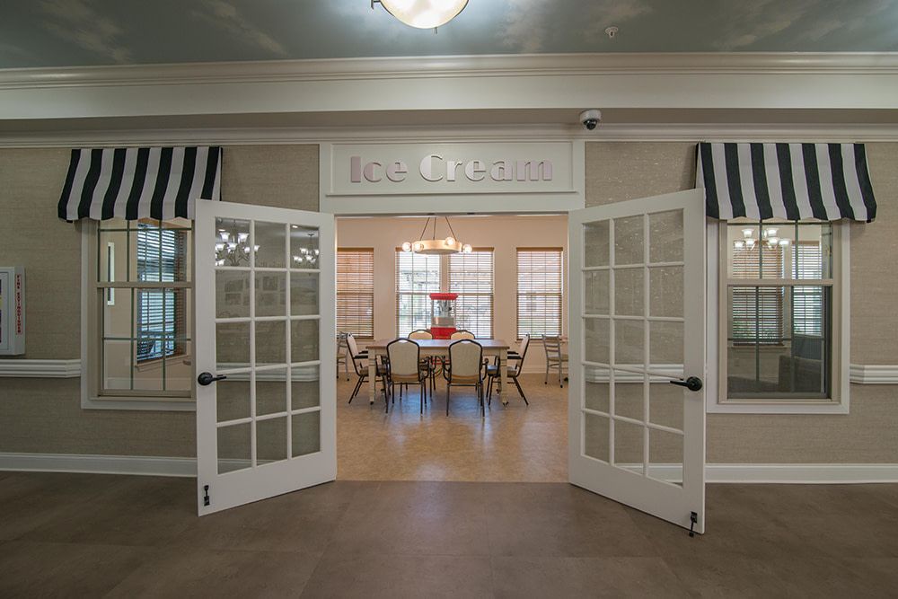 A cozy dining area with open French doors leading to a brightly lit room.