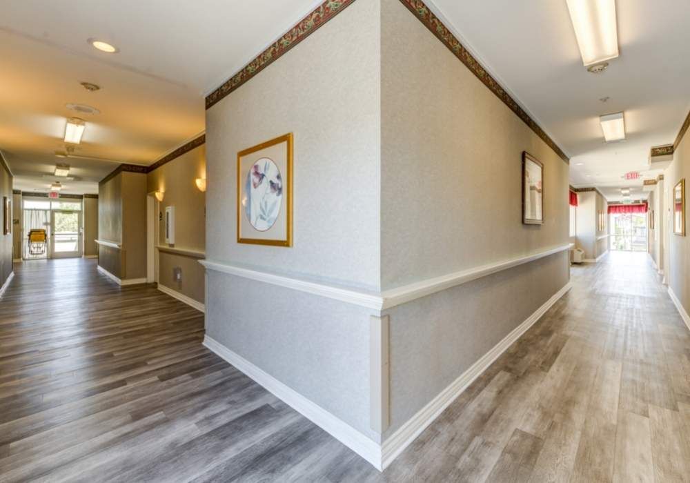 A modern hallway with light-colored walls, decorative lighting, and framed artwork.