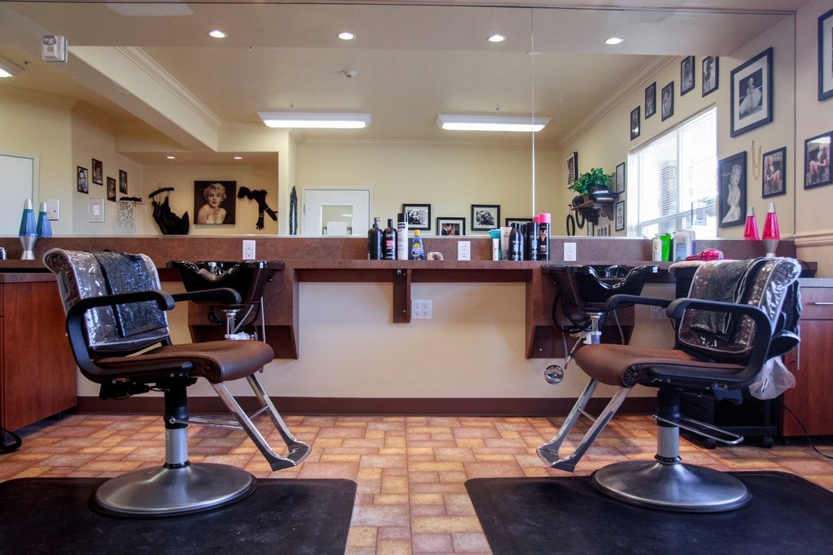 An empty barbershop interior with chairs and mirrors.