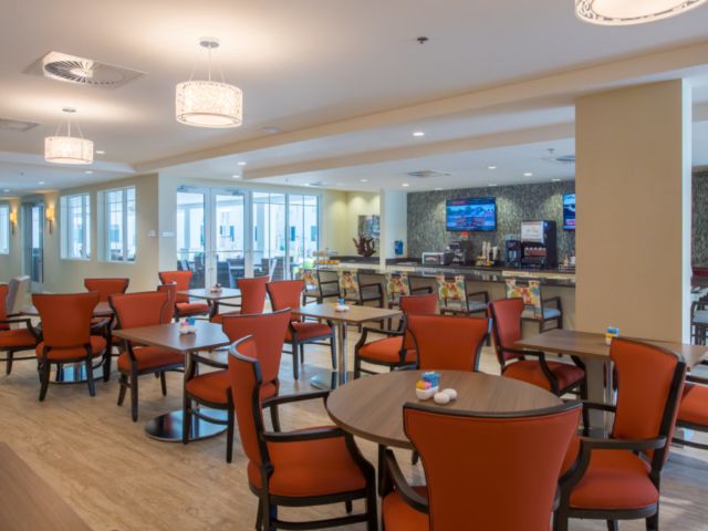 A modern cafe interior with neatly arranged tables and chairs.