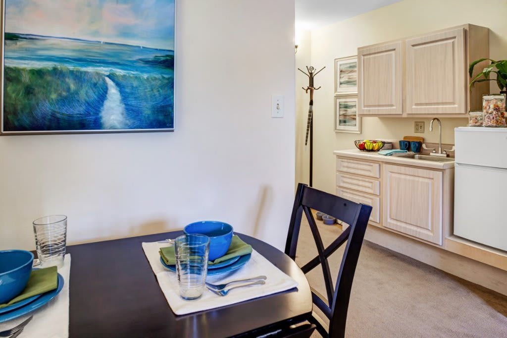 A cozy dining area with a neatly set table and visible kitchen in the background.