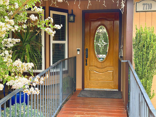 A welcoming entrance featuring a wooden door and beautiful plant decor.
