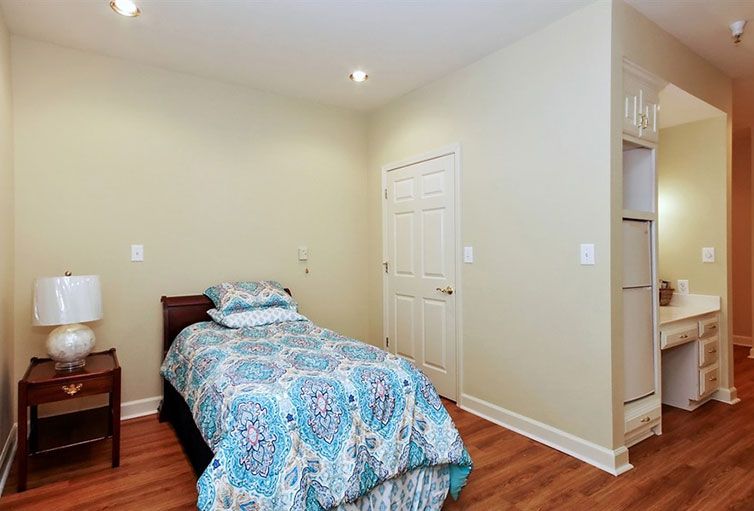 A minimalist bedroom featuring a single bed with colorful bedding.