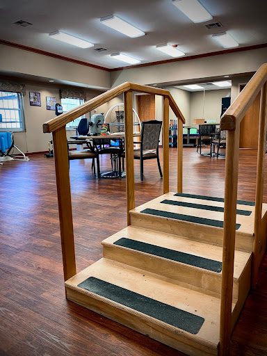 A set of wooden stairs designed for rehabilitation or exercise, located in an indoor facility.