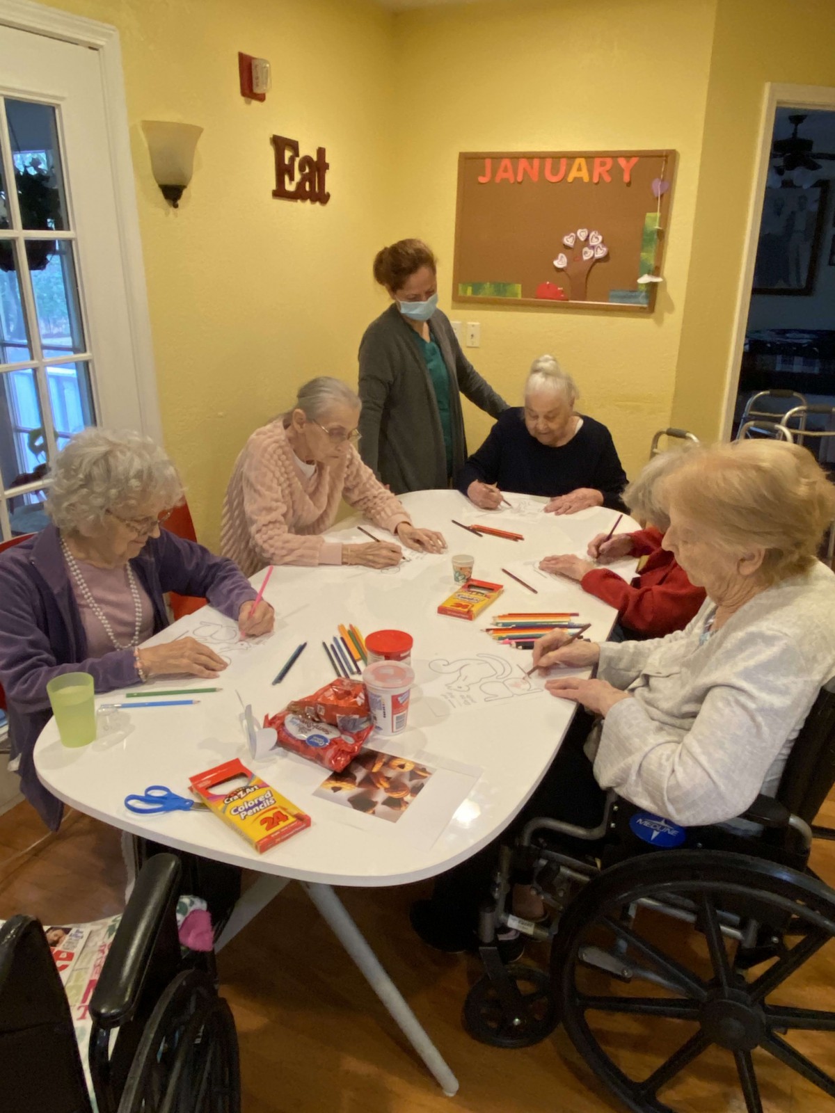 A group of seniors participate in a coloring activity at a care facility.