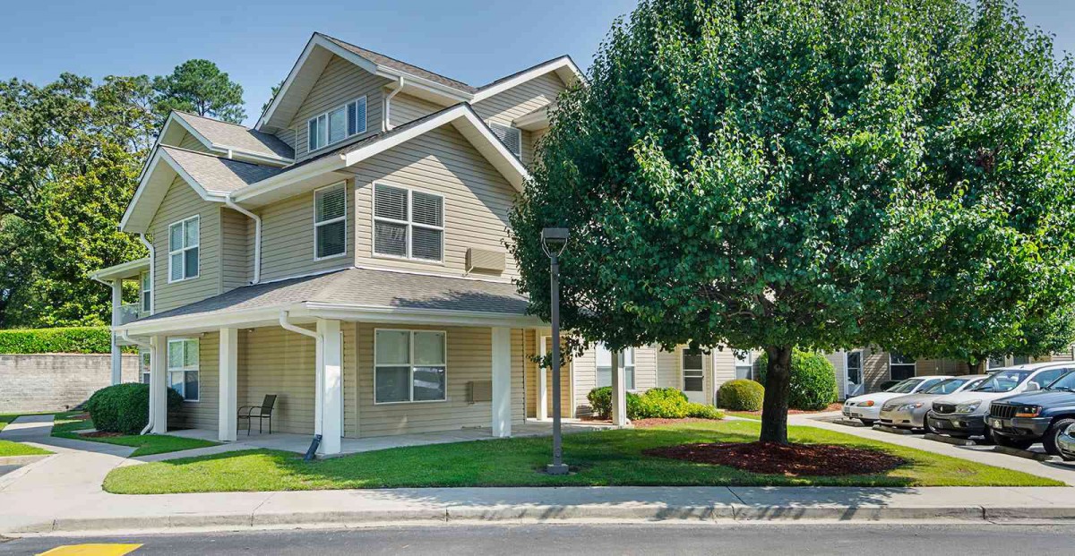 A suburban residential house with a well-maintained exterior and a large tree in the front yard.
