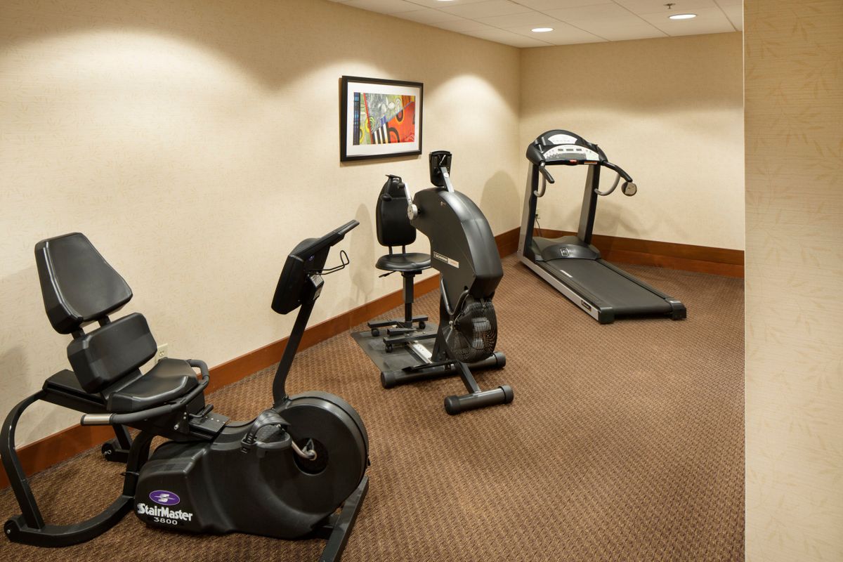 A small indoor gym with exercise equipment including a treadmill and stationary bikes.