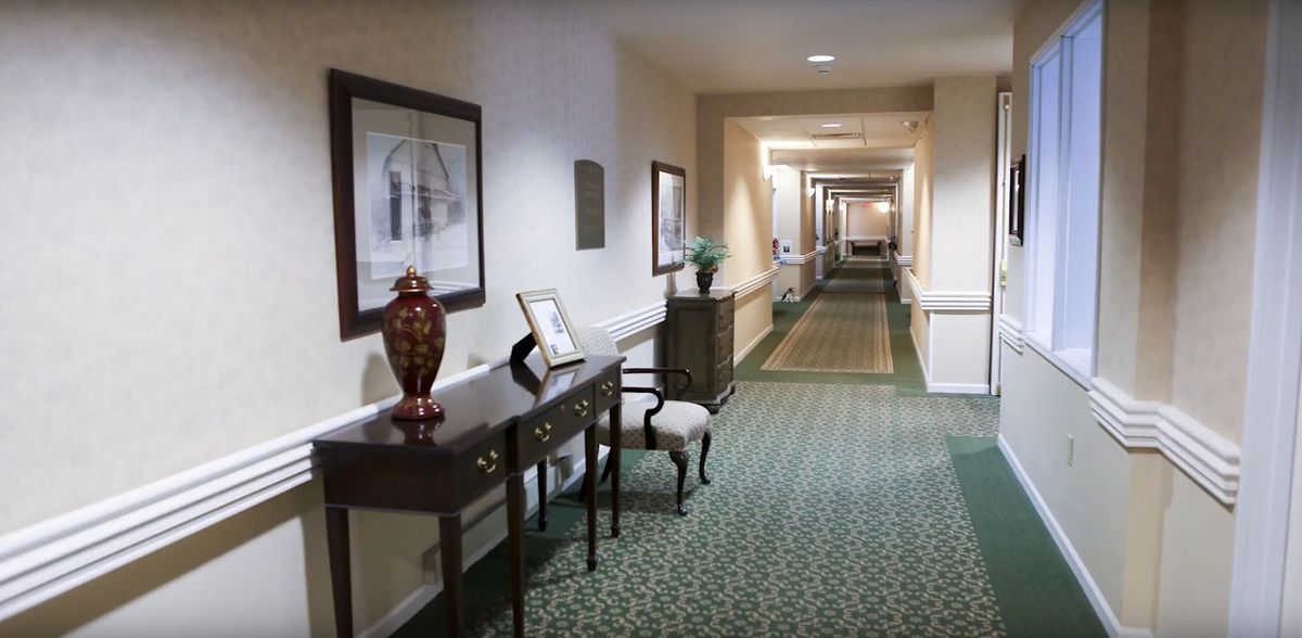 A decorated hotel hallway with carpet and furniture.