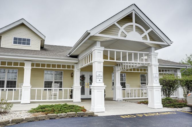 A residential building with a covered entrance and decorative columns.