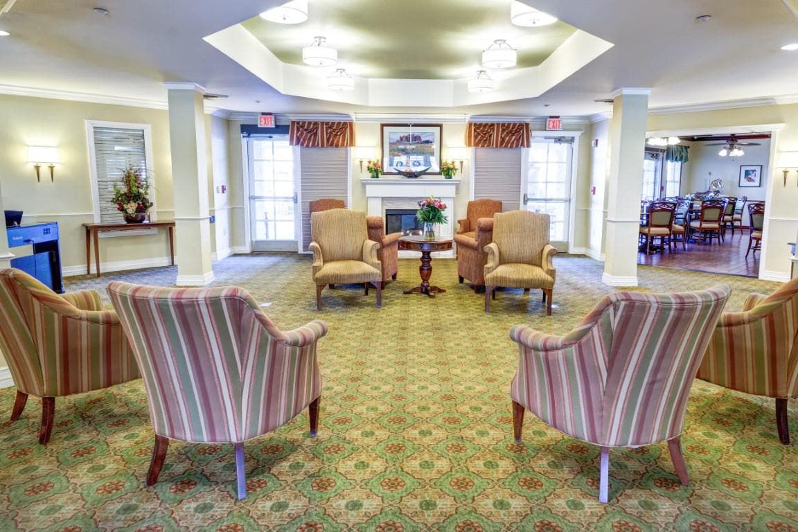 A cozy seating area with armchairs arranged around a fireplace.