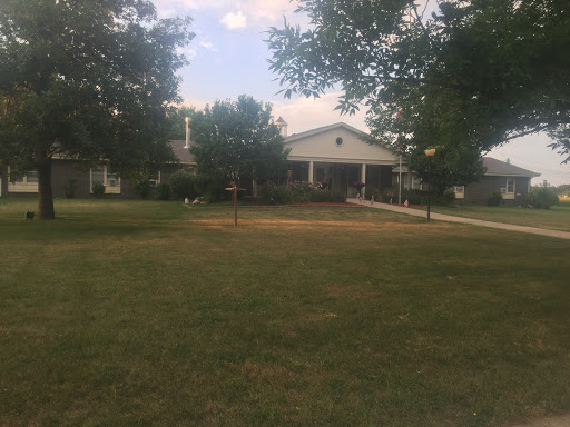 A peaceful suburban home with a well-kept lawn and ample trees.