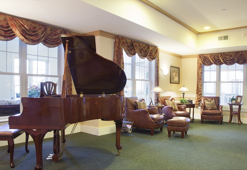 A cozy living room with elegant decor, featuring a grand piano and comfortable seating.