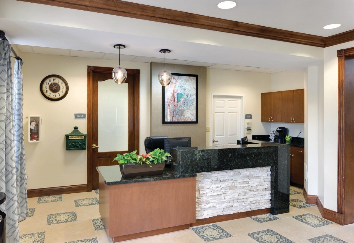A modern and neatly designed office reception area with a front desk.