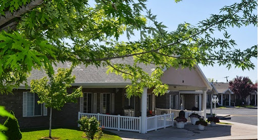 A charming residential house surrounded by lush green trees and a welcoming porch.