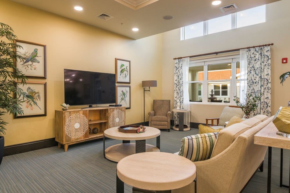 A cozy living room with modern furniture and a large television.