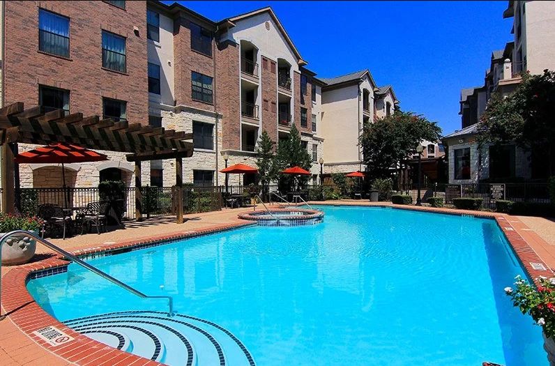 An apartment complex with a large outdoor swimming pool.