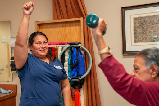 A healthcare professional guides a client through an exercise session with weights, promoting fitness and rehabilitation.