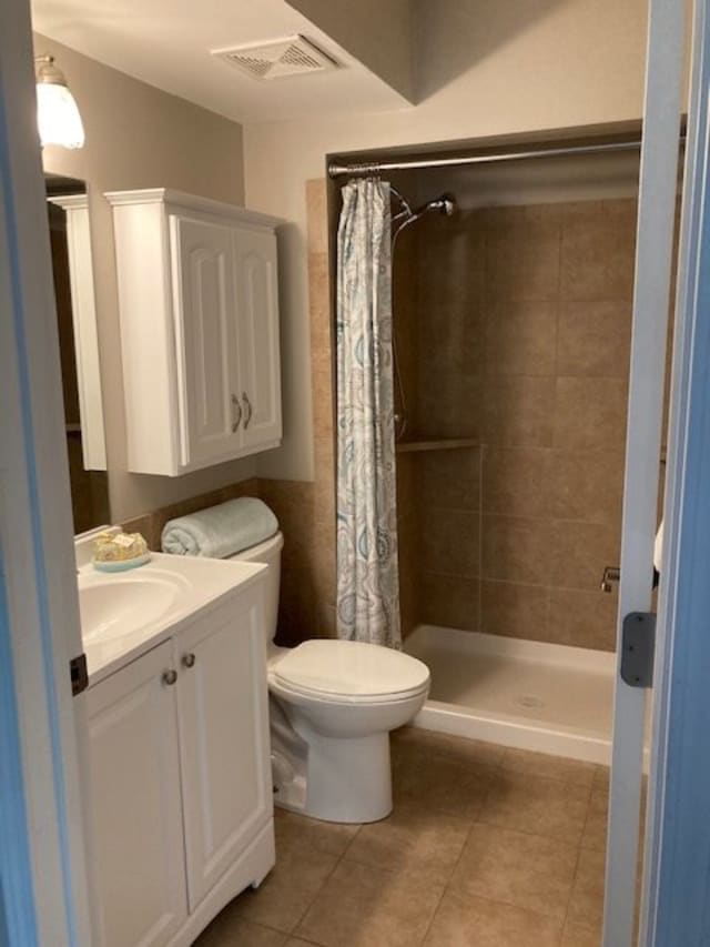 A bathroom featuring a shower, toilet, sink, and cabinet with a towel.