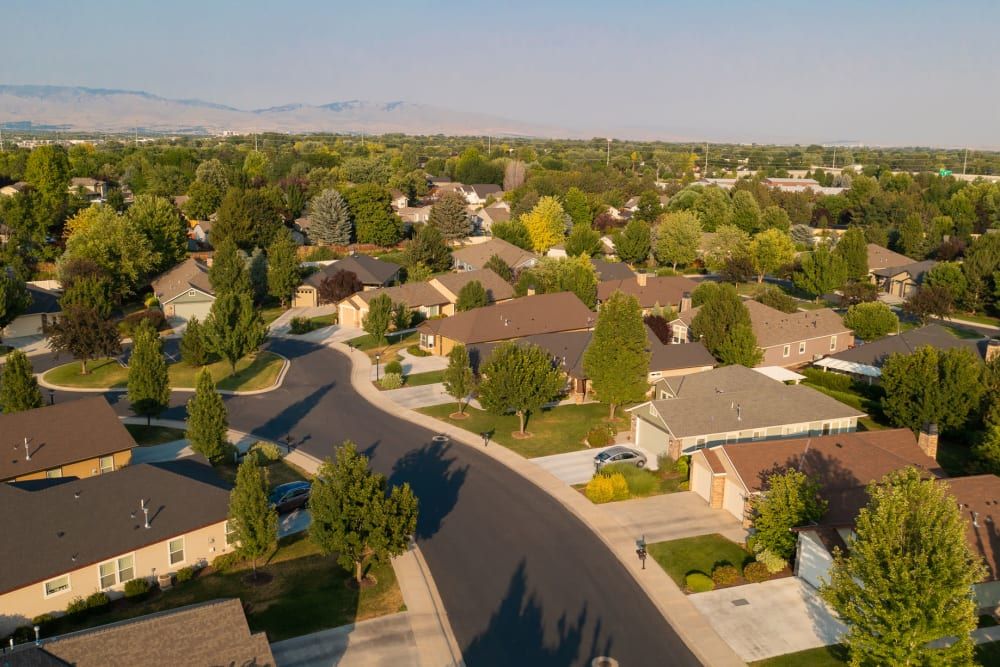 Aerial view of a suburban neighborhood with houses and tree-lined streets.
