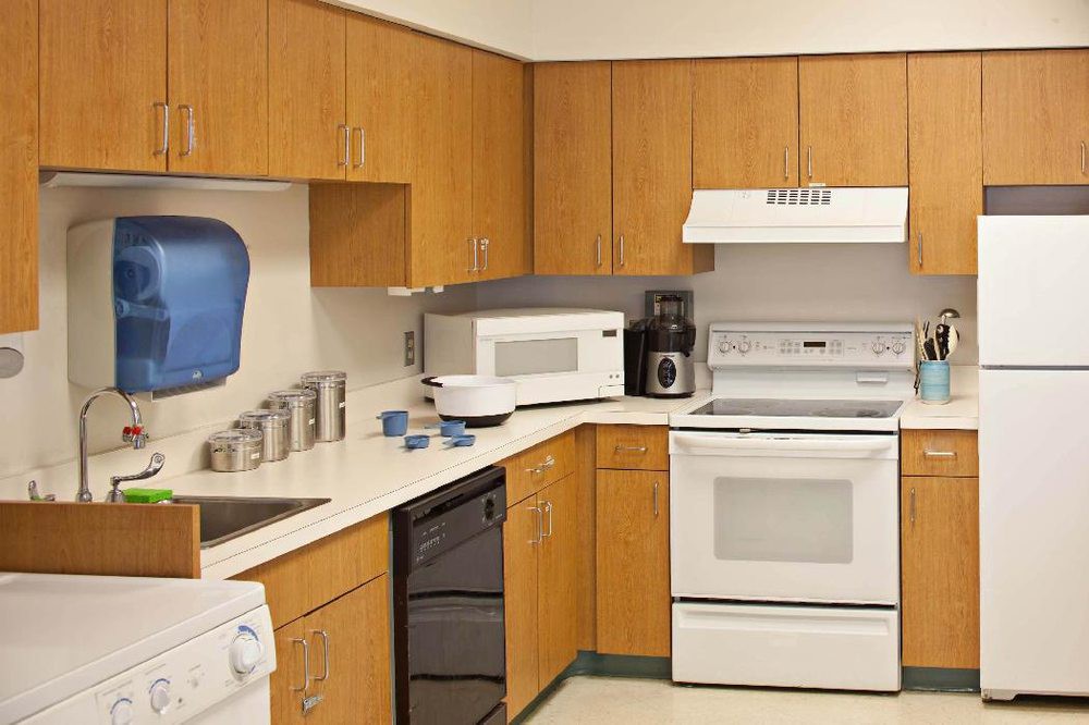 A modern kitchen featuring wooden cabinets and essential appliances.