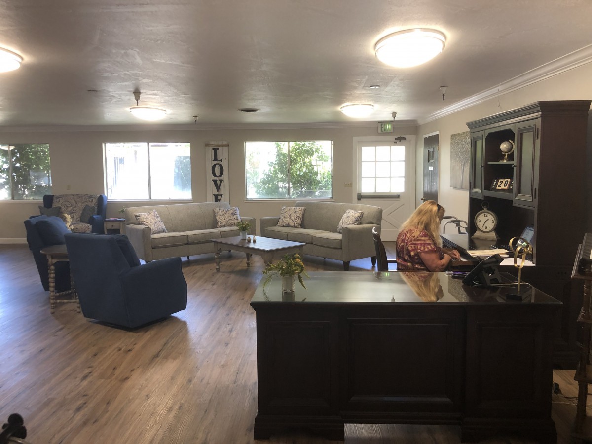 A spacious office area with a person working at a desk and comfortable seating.