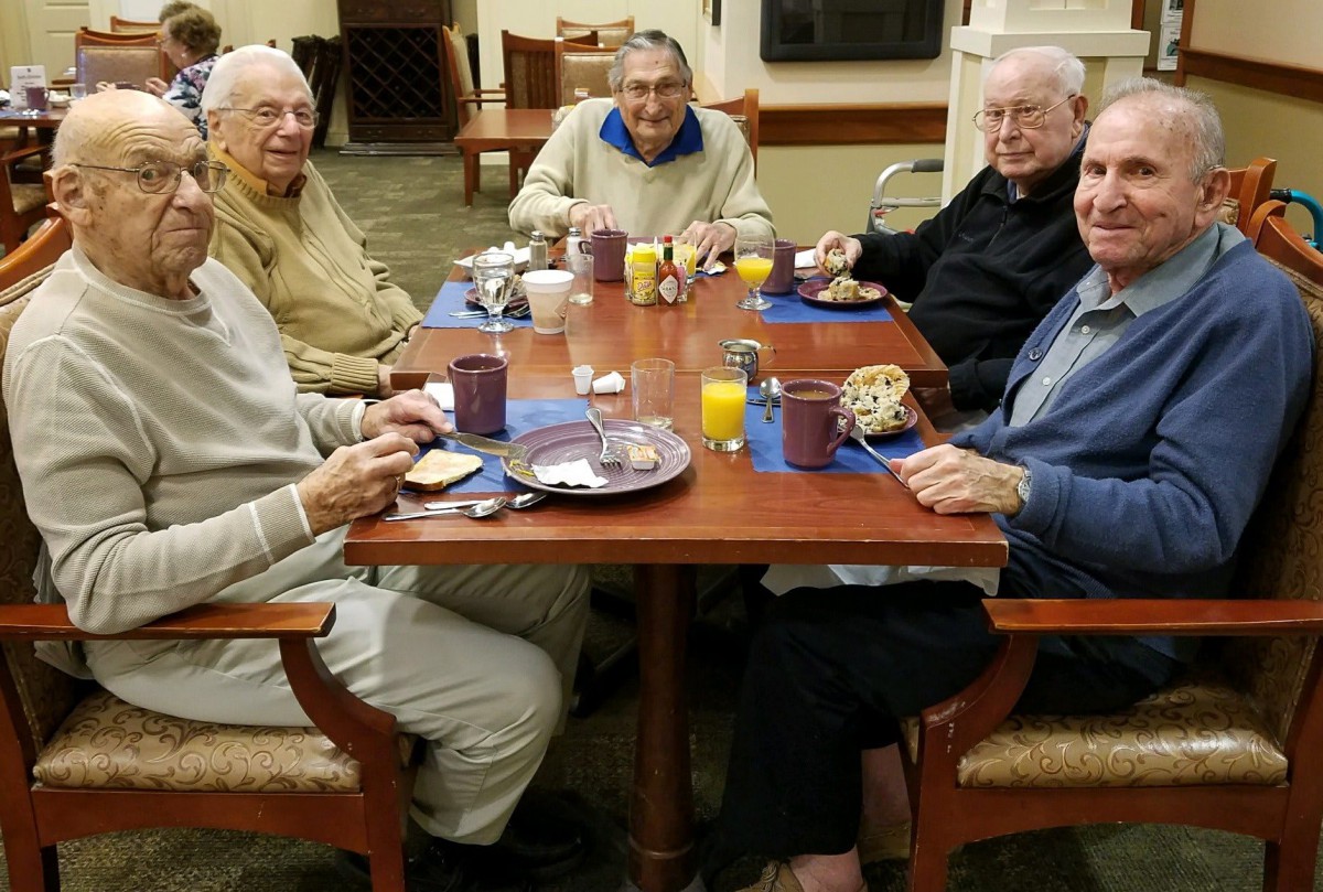 A group of seniors enjoying a meal together at a dining table.