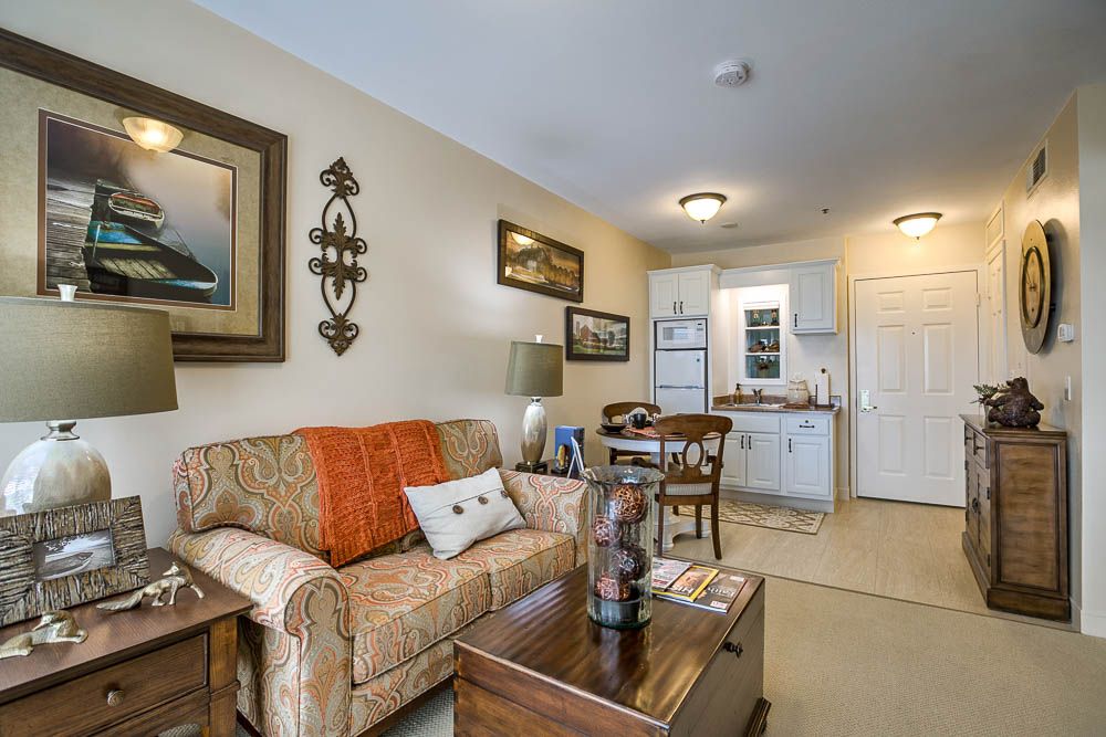 A cozy living room with an integrated kitchen and dining area, featuring elegant decor and comfortable furnishings.