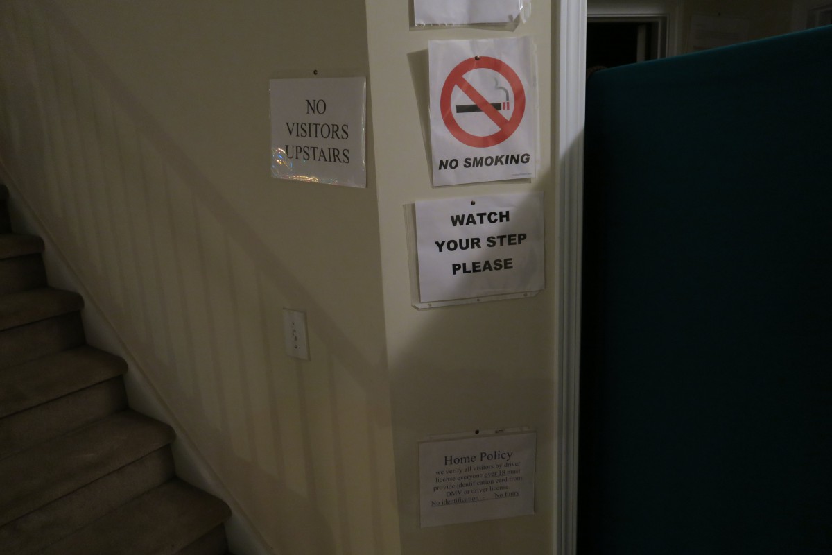 A wall with several warning signs near a staircase.
