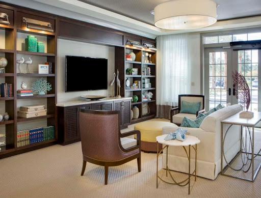 A cozy and modern living room featuring stylish furniture and a well-organized bookshelf.