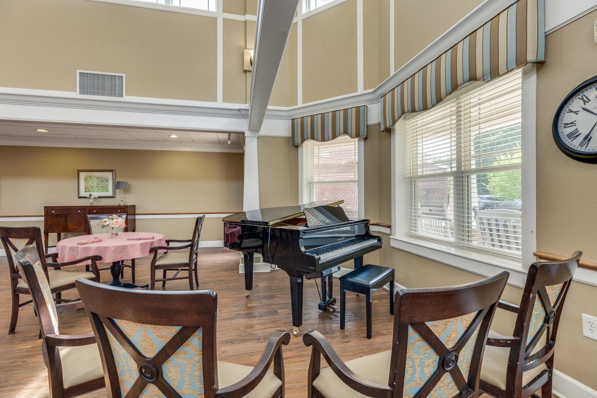 A cozy music room with a grand piano and seating area.
