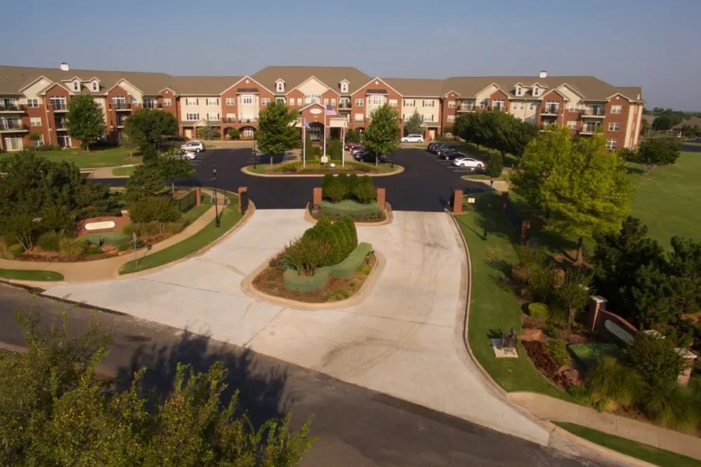 Aerial view of a large building with a landscaped entrance and parking lot.