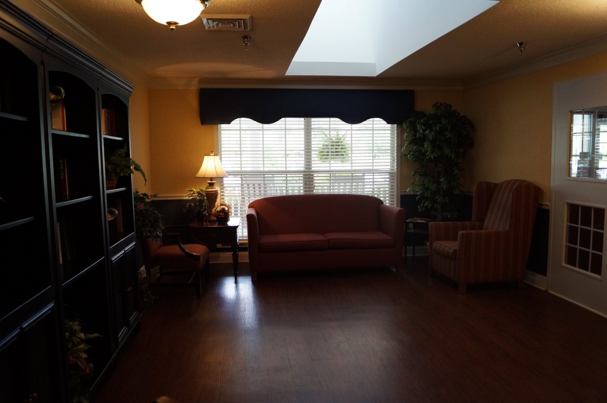 A cozy living room with a sofa and large window letting in natural light.
