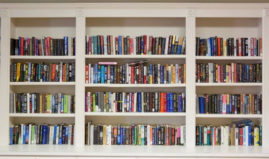 A neatly arranged bookshelf filled with a variety of books.