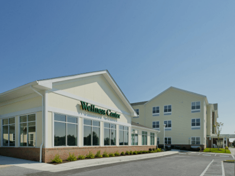 A modern wellness center facility under a clear blue sky.