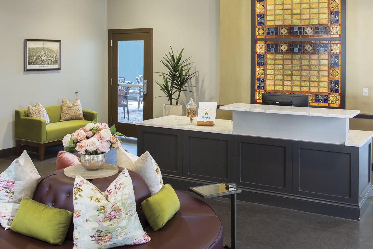 A modern reception area with comfortable seating, floral decorations, and a welcoming atmosphere.