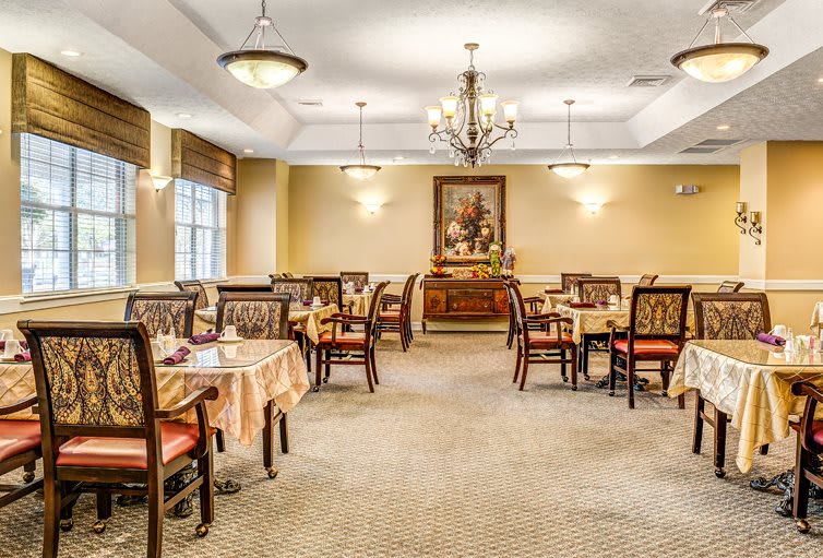 Elegant dining room with chandeliers and neatly arranged tables and chairs.